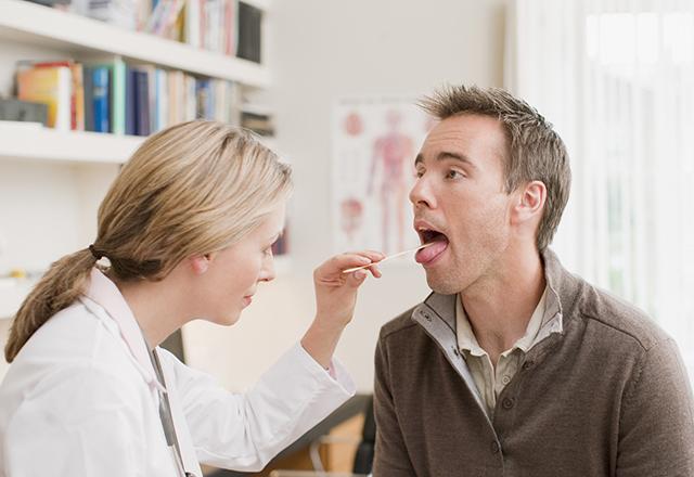 doctor examines patients throat