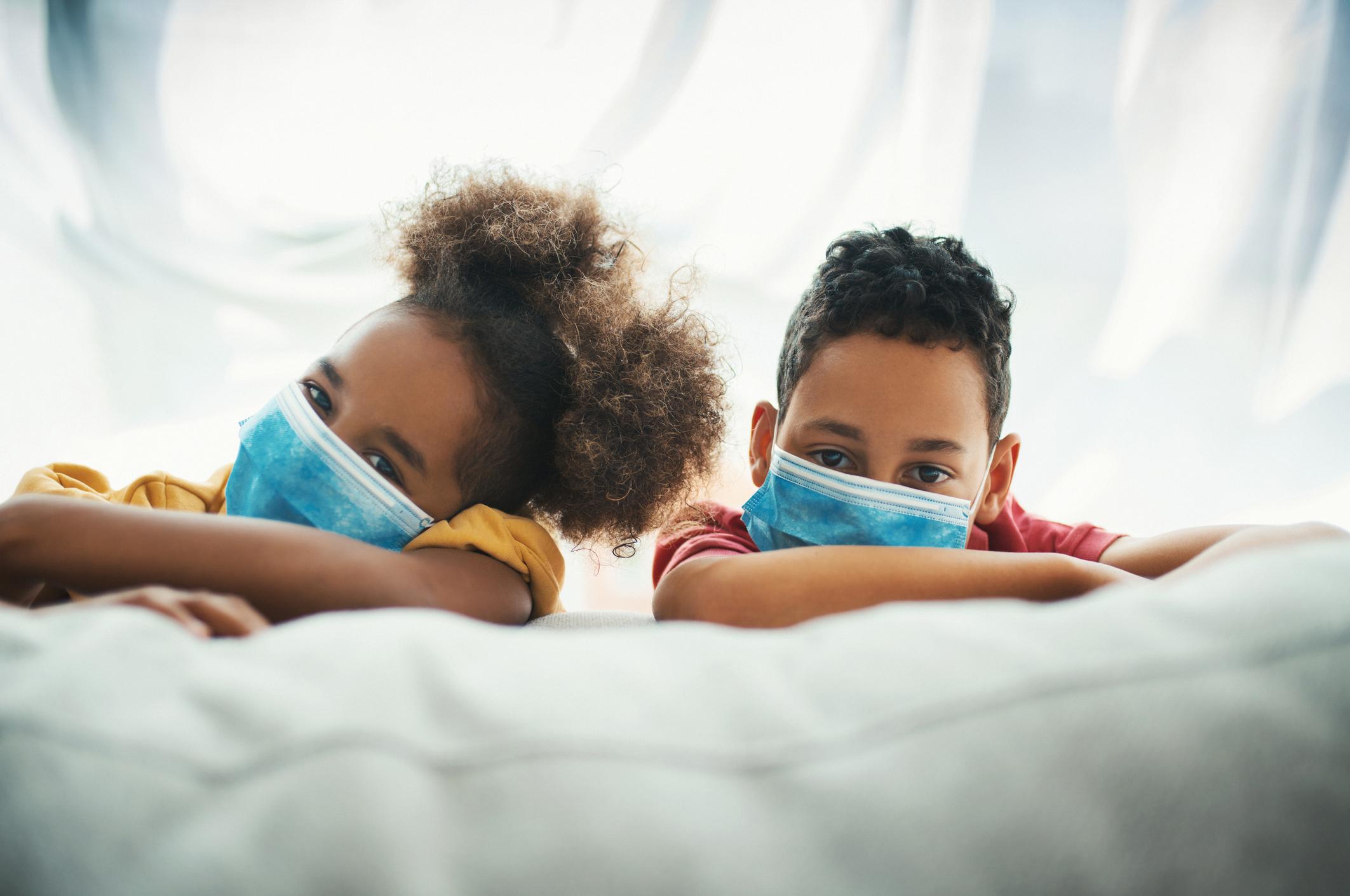 kids wearing a mask on a couch